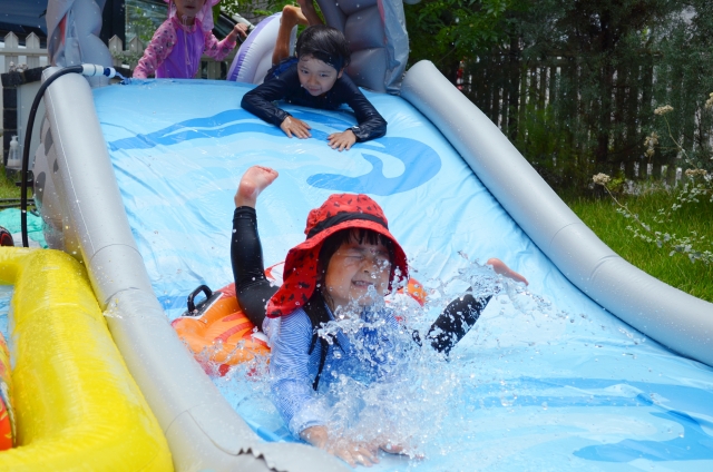 帽子をかぶり水遊びを楽しむ子供たち